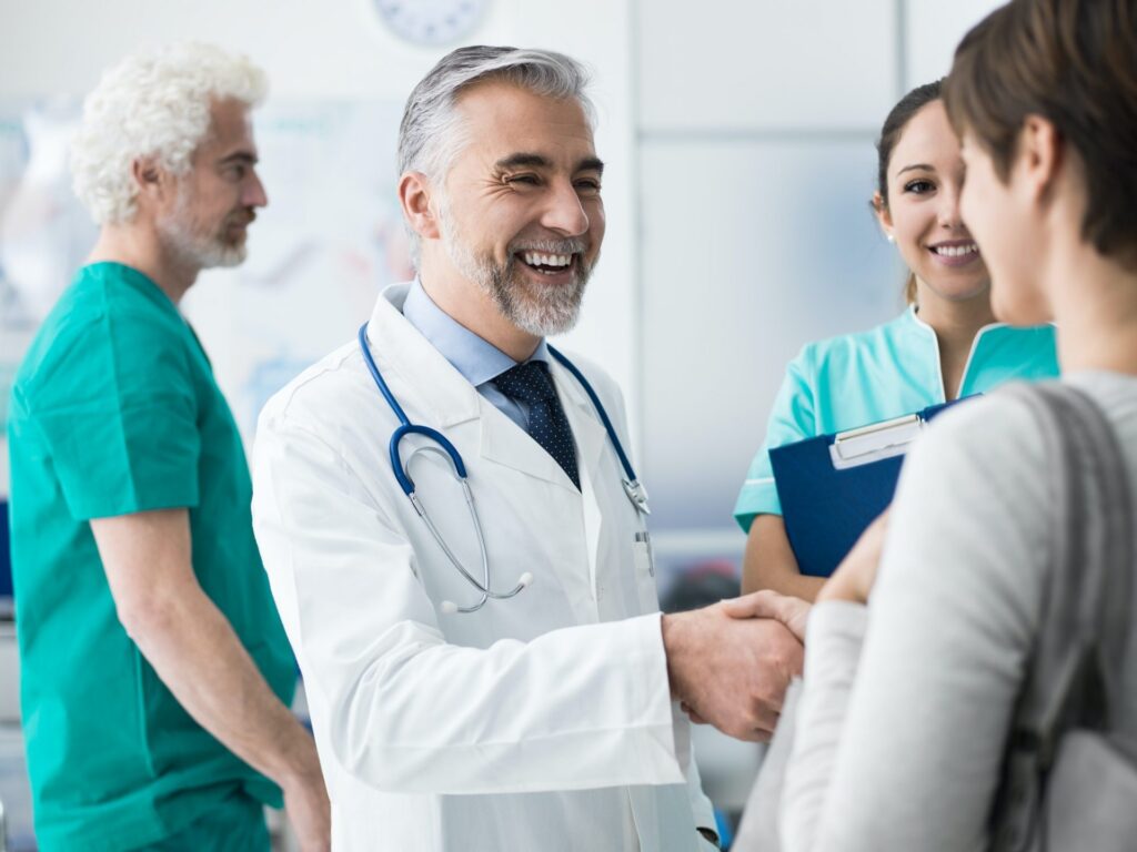 confident doctor shaking patient s hand e1623252367541